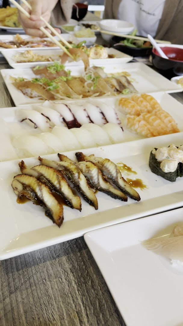 A casual sushi bar with seated guests.